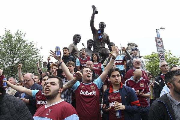 Fans sing songs by the World Cup winners statue before the final match against Man Utd