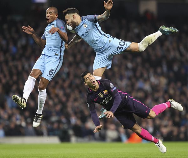 Manchester City's Fernando and Nicolas Otamendi compete for the ball with Luis Suarez