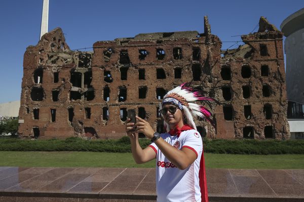 A Tunisia fan takes a selfie in front of Grudinin's Mill in Volgograd before their match against England