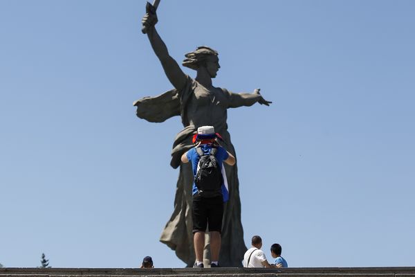 A fan takes a photo of the Motherland Calls statue outside Volgograd Arena