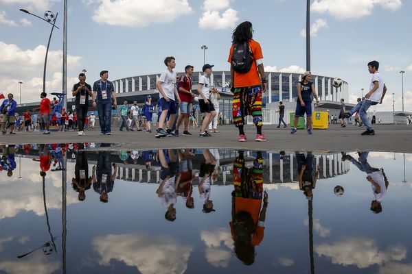 Fans play football outside the stadium before the match between England and Panama