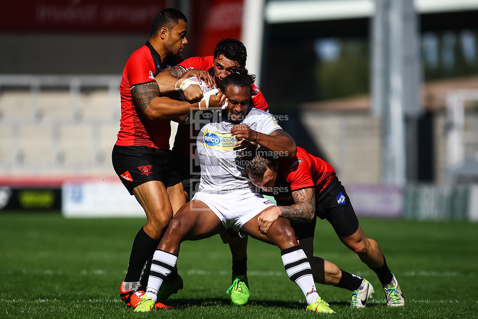 Josh Drinkwater of London Broncos is tackled by three Salford players