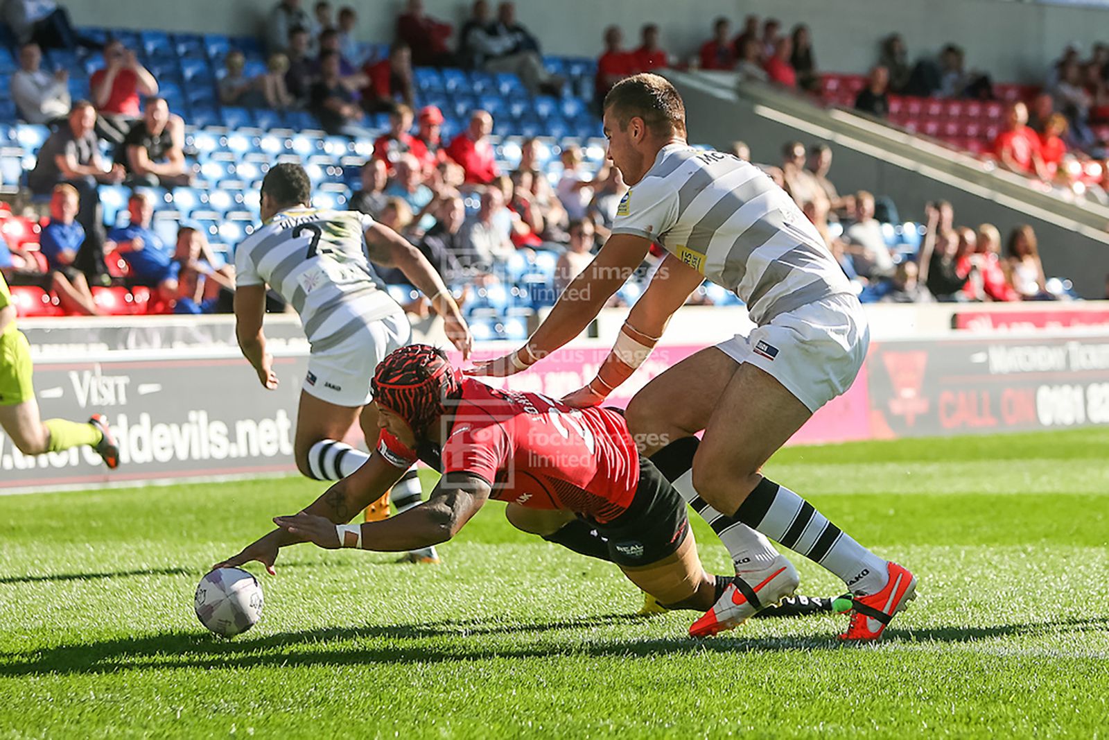 A rare bit of egg-chasing as Salford Red Devils take on London Broncos. Here Greg Johnson scores a try.