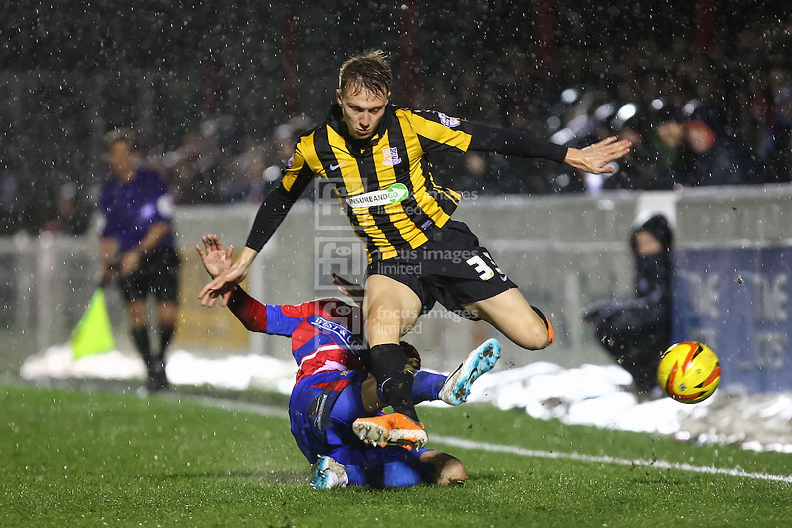 Scott Doe slides in on Cauley Woodrow as the rain pours