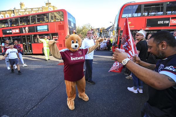 A woman dressed as a bear with a West Ham shirt on poses